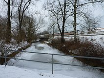 Winter 2012: zugefrorene 'Lache', Bahndamm mit ICE, links der Spielplatz (13. Februar 2012)